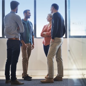 Shot of four coworkers having an informal discussion in an open plan office